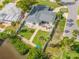 Aerial view of a house's backyard with a white fence, patio, and landscaping near the water at 716 Palm Circle Dr, Port Orange, FL 32127