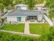 The house has a backyard patio, white fence, and lush, mature landscaping near the water at 716 Palm Circle Dr, Port Orange, FL 32127