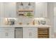 Wet bar features custom herringbone backsplash, open shelving, wine fridge, and countertop with beverage center at 716 Palm Circle Dr, Port Orange, FL 32127
