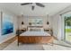 Primary bedroom with wood look floors, king bed, backyard access, and ceiling fan at 716 Palm Circle Dr, Port Orange, FL 32127