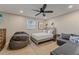 Cozy bedroom with a ceiling fan, a comfortable bed, and a gray couch with pillows at 716 Palm Circle Dr, Port Orange, FL 32127