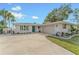 Charming white brick home featuring a well-manicured lawn and attached garage at 716 Palm Circle Dr, Port Orange, FL 32127