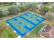 Aerial view of two outdoor basketball courts with vibrant blue and green surfaces, enhanced by surrounding landscaping at 741 Maderia Ct, Kissimmee, FL 34758