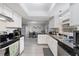 Well-lit kitchen with stainless steel dishwasher, black countertops, and views to dining and living area at 741 Maderia Ct, Kissimmee, FL 34758