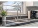 Close-up of kitchen sink featuring modern fixtures, stainless steel sink and a window view at 741 Maderia Ct, Kissimmee, FL 34758