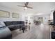 Spacious open-plan living room with modern gray floors, ceiling fan, and view to dining area at 741 Maderia Ct, Kissimmee, FL 34758