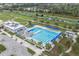 Aerial view of the neighborhood pool featuring multiple lanes and blue canopies with palm trees in the background at 741 Maderia Ct, Kissimmee, FL 34758