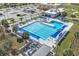 Aerial of community pool with lane dividers, lounge chairs, shade structures, and a nearby parking lot at 741 Maderia Ct, Kissimmee, FL 34758