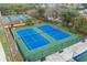 Aerial of two well-kept tennis courts surrounded by green space and complemented by benches and fencing at 741 Maderia Ct, Kissimmee, FL 34758