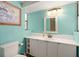 Aqua colored bathroom featuring a toilet, white vanity with modern lighting, and bright natural light at 7730 Pineapple Dr, Orlando, FL 32835