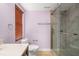 Bright bathroom with a glass-enclosed shower, toilet, and a window with wood blinds for natural light at 7730 Pineapple Dr, Orlando, FL 32835