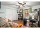 Bedroom with a futon, work desk, and a window with wood blinds, ceiling fan, and laminate wood floors at 7730 Pineapple Dr, Orlando, FL 32835
