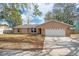 Charming single-story home with a well-manicured lawn, attached garage, and inviting facade at 7730 Pineapple Dr, Orlando, FL 32835
