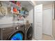 Well-organized laundry room with front-loading washer and dryer, shelving, and ample storage space at 7730 Pineapple Dr, Orlando, FL 32835