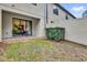 Private backyard featuring a covered patio, manicured hedge, and sliding glass doors at 8201 Roseville Rd, Davenport, FL 33896
