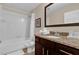Bathroom featuring shower-tub combo, granite vanity top with sink and dark brown cabinetry at 8201 Roseville Rd, Davenport, FL 33896