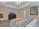 Spacious bedroom featuring wood floors, tray ceiling, and a decorative yellow throw blanket at 8201 Roseville Rd, Davenport, FL 33896