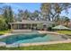 Backyard area featuring a pool, patio furniture, a screened-in patio and a lush green lawn at 1525 Orange Tree Dr, Edgewater, FL 32132