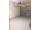 A clean garage featuring painted walls and floor, along with a functional garage door and opener at 1560 Chelsea Dr, Davenport, FL 33897