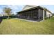 Exterior view of the screened-in patio extending into the well-manicured lawn with fenced yard at 16410 Taliesin St, Winter Garden, FL 34787