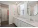 Bathroom featuring double sinks, quartz counters, modern fixtures, and a walk-in closet at 16410 Taliesin St, Winter Garden, FL 34787