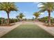 Relaxing community space with artificial turf, palm trees and a splash pad in the background at 16410 Taliesin St, Winter Garden, FL 34787