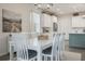 Bright dining room featuring a white table set, stylish chandelier, and an adjacent modern kitchen at 16410 Taliesin St, Winter Garden, FL 34787