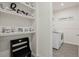 Hallway with shelving and bench leading to a laundry room with modern washer and dryer at 16410 Taliesin St, Winter Garden, FL 34787