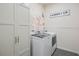 Convenient laundry room featuring modern washer and dryer, floral accents, and ample storage at 16410 Taliesin St, Winter Garden, FL 34787