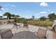 Patio with table and chairs with relaxing seating, landscaping and beautiful lake views at 16410 Taliesin St, Winter Garden, FL 34787