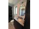 Well lit bathroom featuring oval mirror, granite countertop and modern sink, with tiled shower in the background at 166 Hammock Preserve Loop, Winter Garden, FL 34787