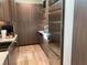 Modern kitchen featuring wood cabinetry, stainless steel refrigerator, light countertops, and wood flooring at 166 Hammock Preserve Loop, Winter Garden, FL 34787