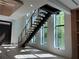 Modern staircase with black stringers and light wood treads, complemented by abundant natural light at 166 Hammock Preserve Loop, Winter Garden, FL 34787