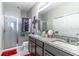 Bathroom featuring double sink vanity, tiled shower, and neutral color palette at 17437 Promenade Dr, Clermont, FL 34711