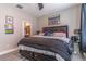 Well-lit bedroom with a decorative ceiling fan, gray floors, and a view of the bathroom at 17437 Promenade Dr, Clermont, FL 34711