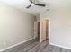 This bedroom boasts a ceiling fan, neutral walls, wood-look floors, and an entry to a closet at 17437 Promenade Dr, Clermont, FL 34711