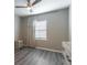 This bedroom is naturally lit and has a ceiling fan, window, and wood-look flooring at 17437 Promenade Dr, Clermont, FL 34711
