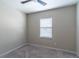 This bedroom features neutral walls and carpeting with a large window and ceiling fan at 17437 Promenade Dr, Clermont, FL 34711