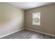 Bright bedroom with gray vinyl plank floors, a window, and neutral paint at 17437 Promenade Dr, Clermont, FL 34711