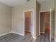 Bedroom with gray vinyl plank floors and two closets, one a walk-in closet at 17437 Promenade Dr, Clermont, FL 34711