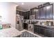 Granite countertops with stainless steel appliances and sleek dark cabinetry in this modern kitchen at 17437 Promenade Dr, Clermont, FL 34711