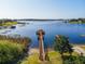 Scenic lake view featuring a private dock with a gazebo and beautiful waterfront homes in the distance at 17437 Promenade Dr, Clermont, FL 34711