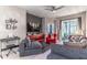 Cozy living room featuring a ceiling fan, gray sofa, red accents, and patio access at 17437 Promenade Dr, Clermont, FL 34711