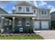 Charming two-story home boasts a manicured lawn, two-car garage, and inviting covered porch at 17505 Glossy Pomelo Way, Winter Garden, FL 34787
