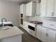 Bright kitchen features white cabinets, stone countertops, and stainless steel appliances at 17505 Glossy Pomelo Way, Winter Garden, FL 34787