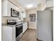 Modern kitchen with granite countertops, stainless steel appliances, and white cabinetry at 1810 Kingsland Ave, Orlando, FL 32808