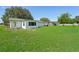 Backyard view with a white house, green grass, and scattered trees at 200 Melissa Ct, Sanford, FL 32773