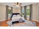 Cozy bedroom with a king-size bed, hardwood floors, a ceiling fan and an area rug at 201 W 16Th St, Sanford, FL 32771