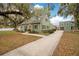 Charming two-story home with green siding, mature trees, and an inviting facade at 201 W 16Th St, Sanford, FL 32771