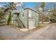 Two-story building with a one-car garage and outdoor staircase is set amongst mature trees at 201 W 16Th St, Sanford, FL 32771